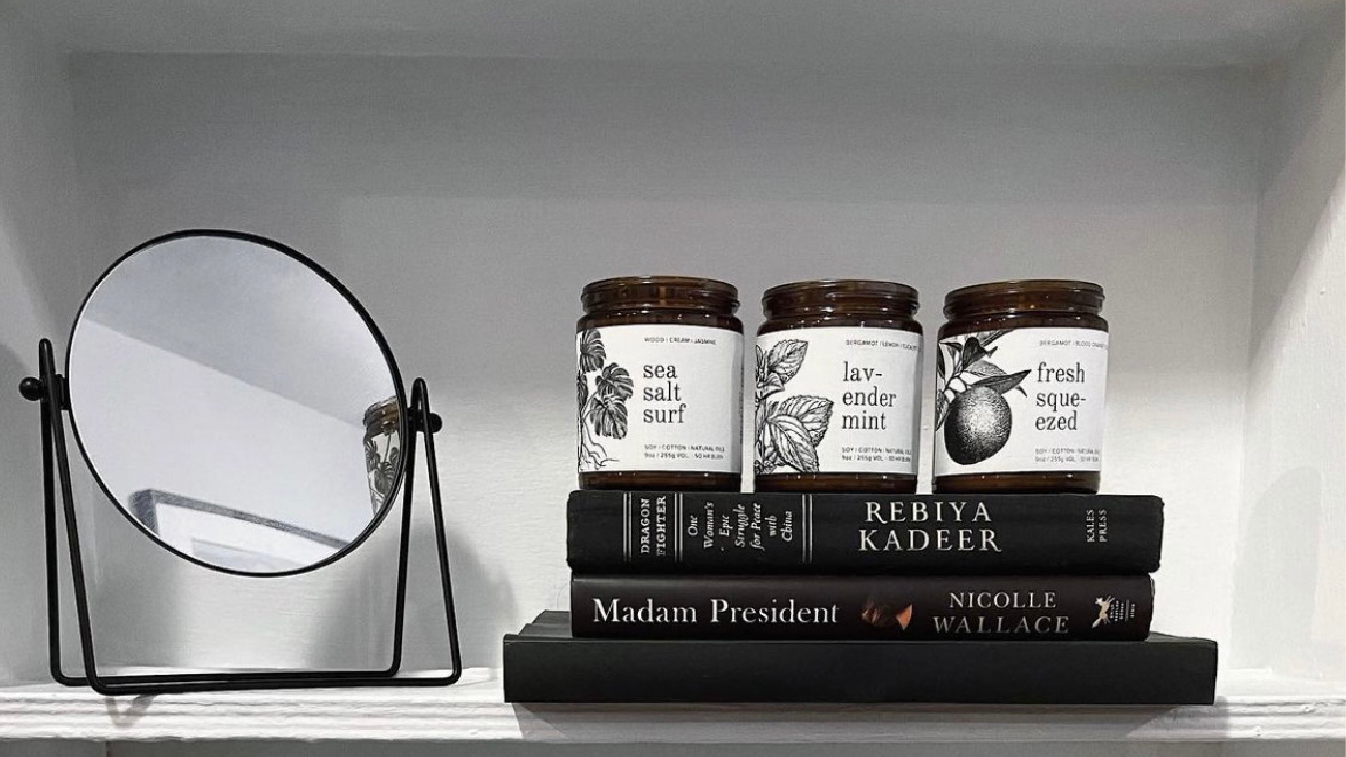 9oz Sea Salt Surf, Lavender Mint, and Fresh Squeezed Soy Candles on top of a stack of books. 