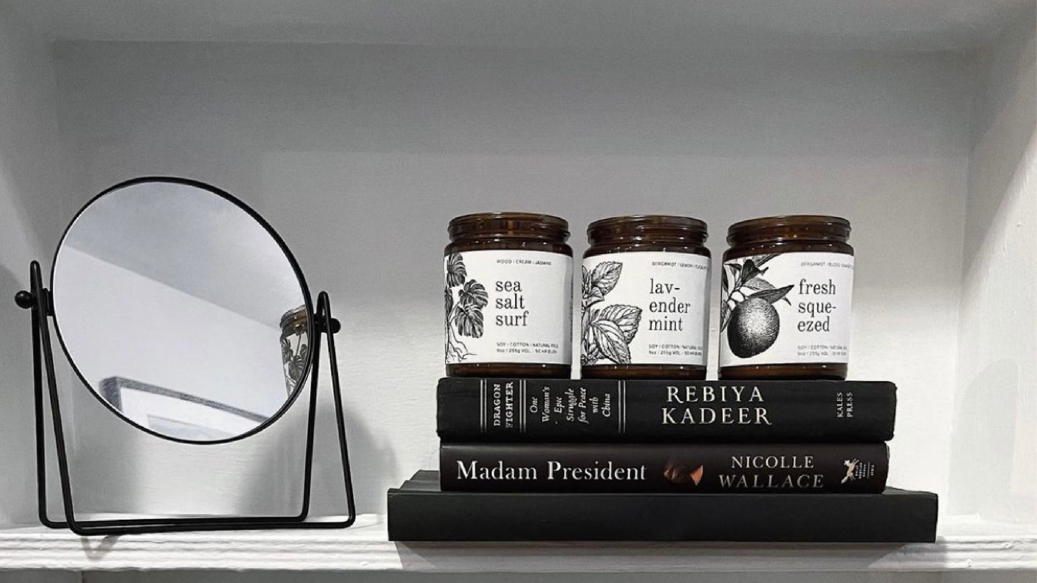 9oz Sea Salt Surf, Lavender Mint, and Fresh Squeezed Soy Candles on top of a stack of books. 