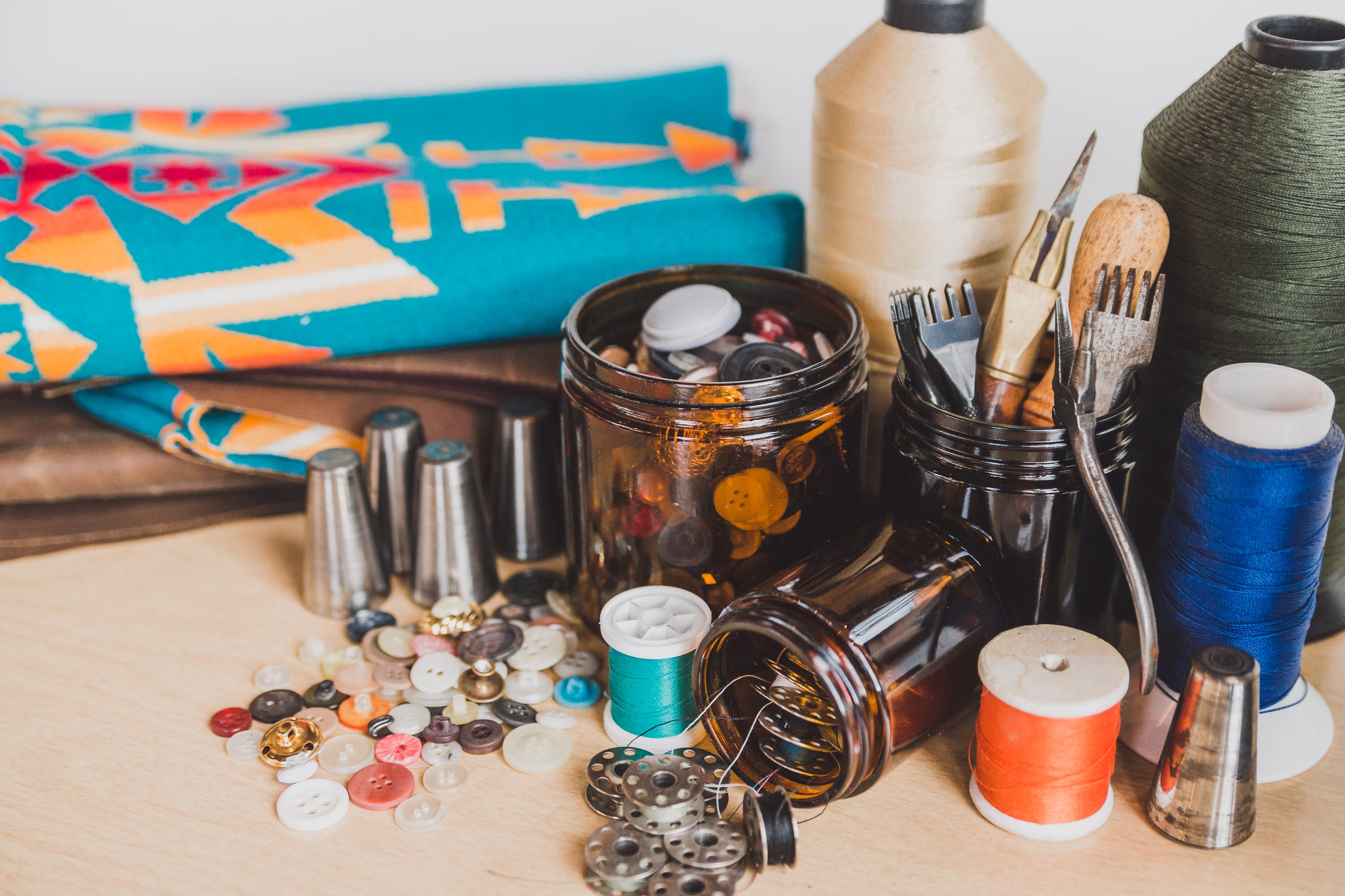 An array of sewing supplies on a wooden table. 