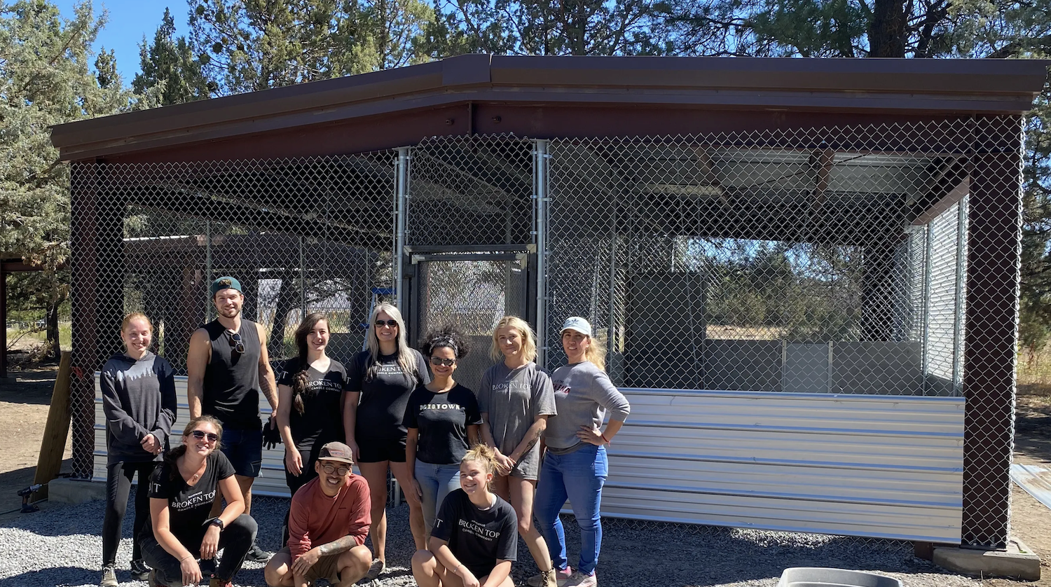 The Broken Top team in front of an animal enclosure. 