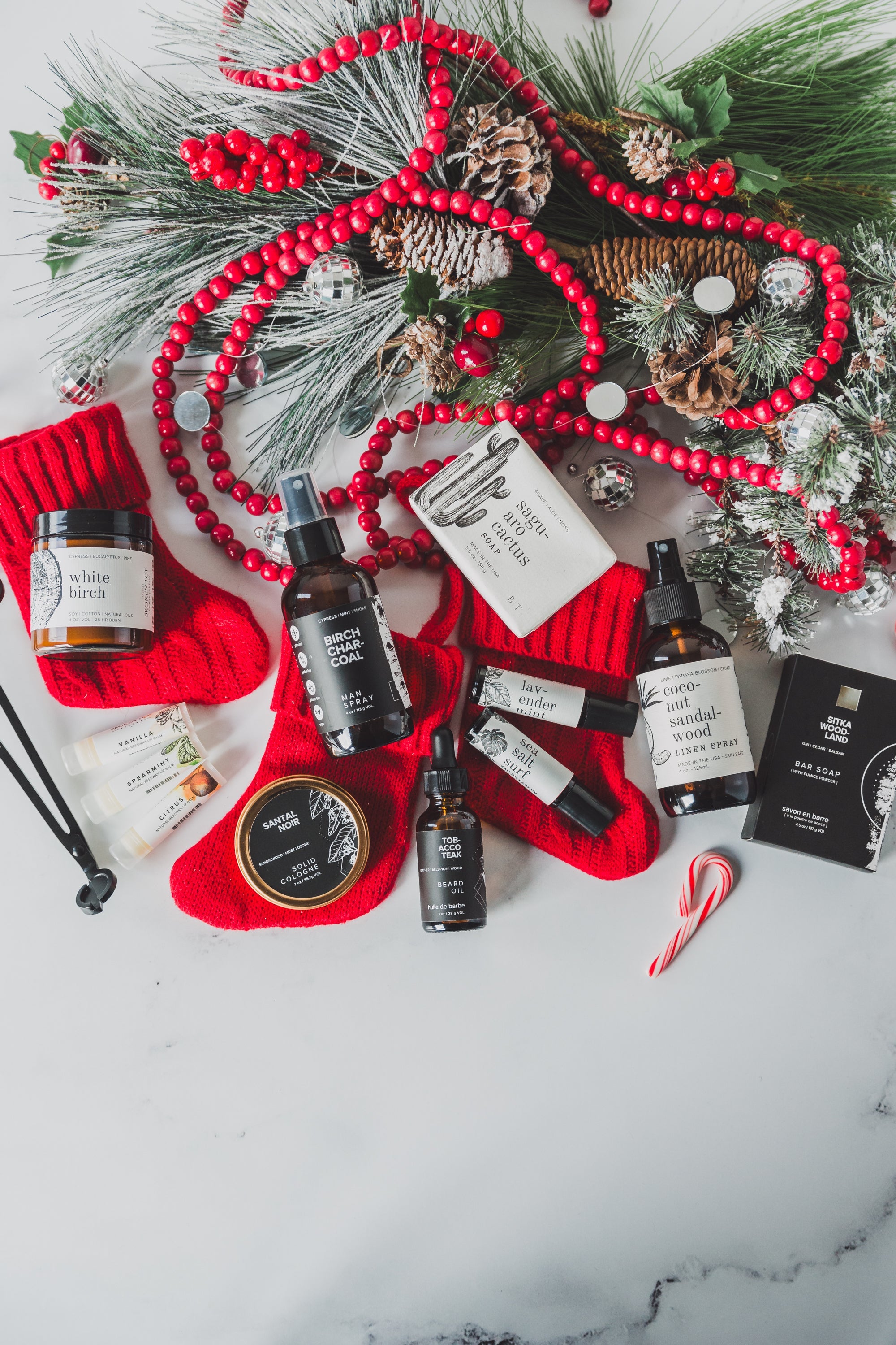An array of Broken Top Brands products atop small red stockings and Christmas decor. 