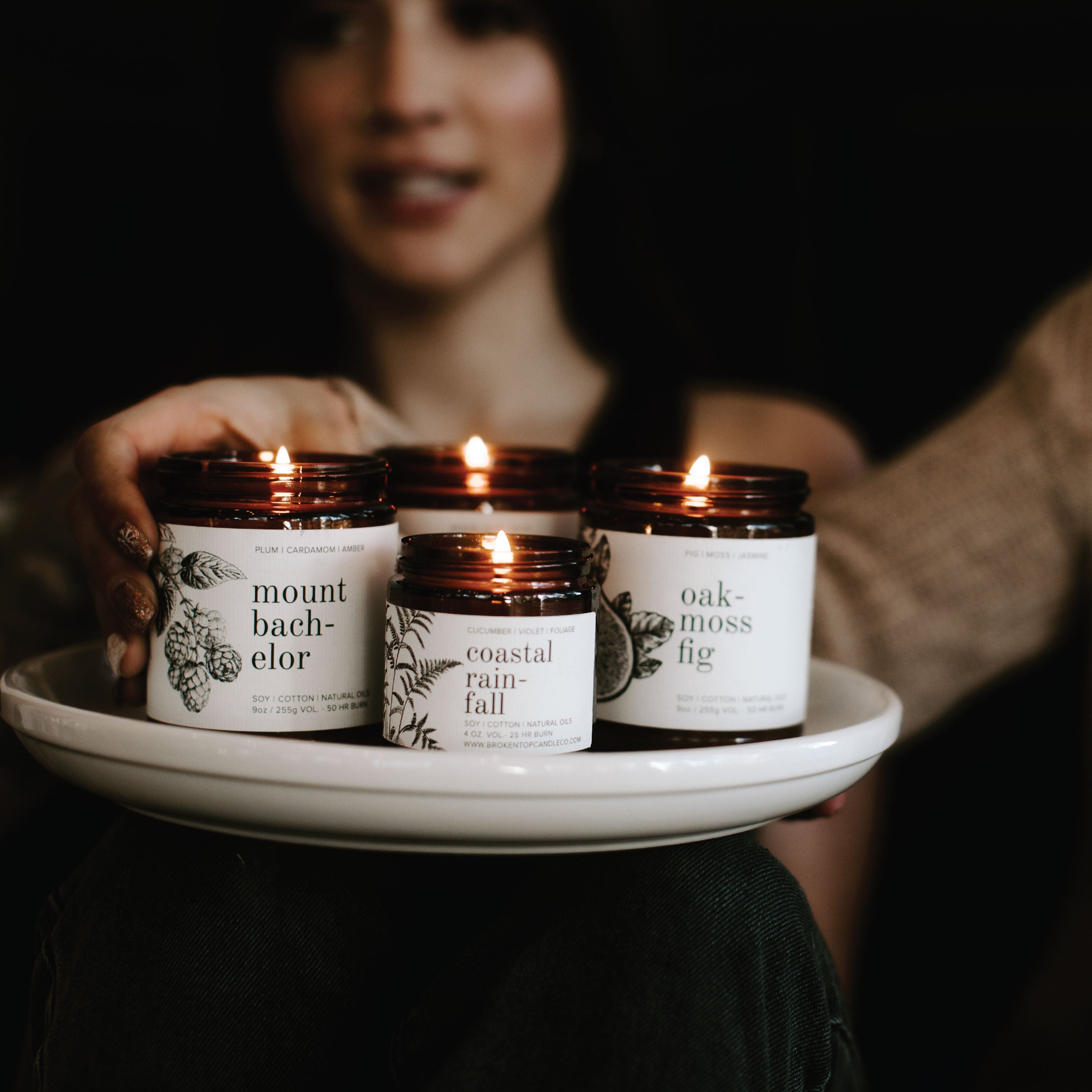 9oz Mount Bachelor Soy Candle, 4oz Coastal Rainfall Soy Candle, and 9oz Oakmoss Fig Soy Candle lit on a white tray. 