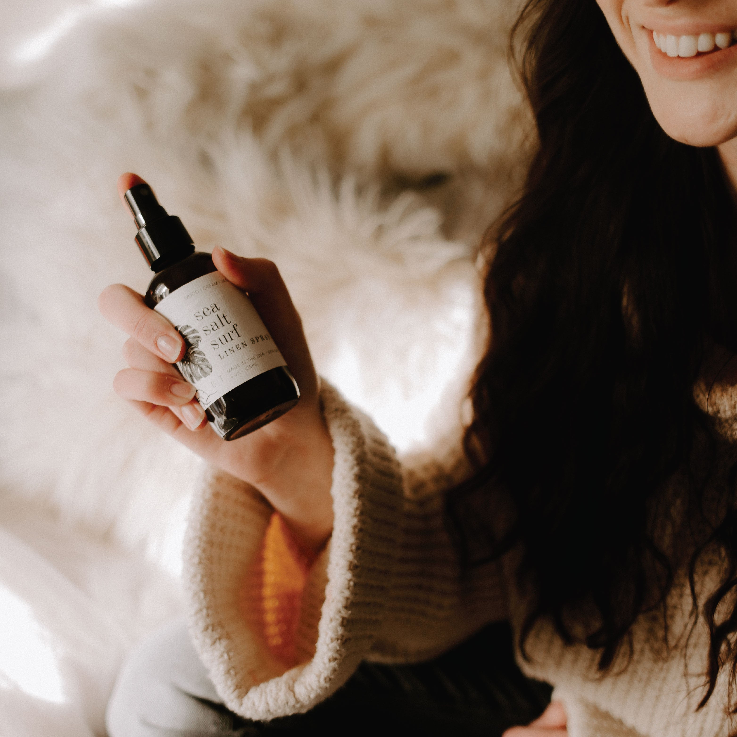 4oz Sea Salt Surf Linen Spray being sprayed by a woman. 