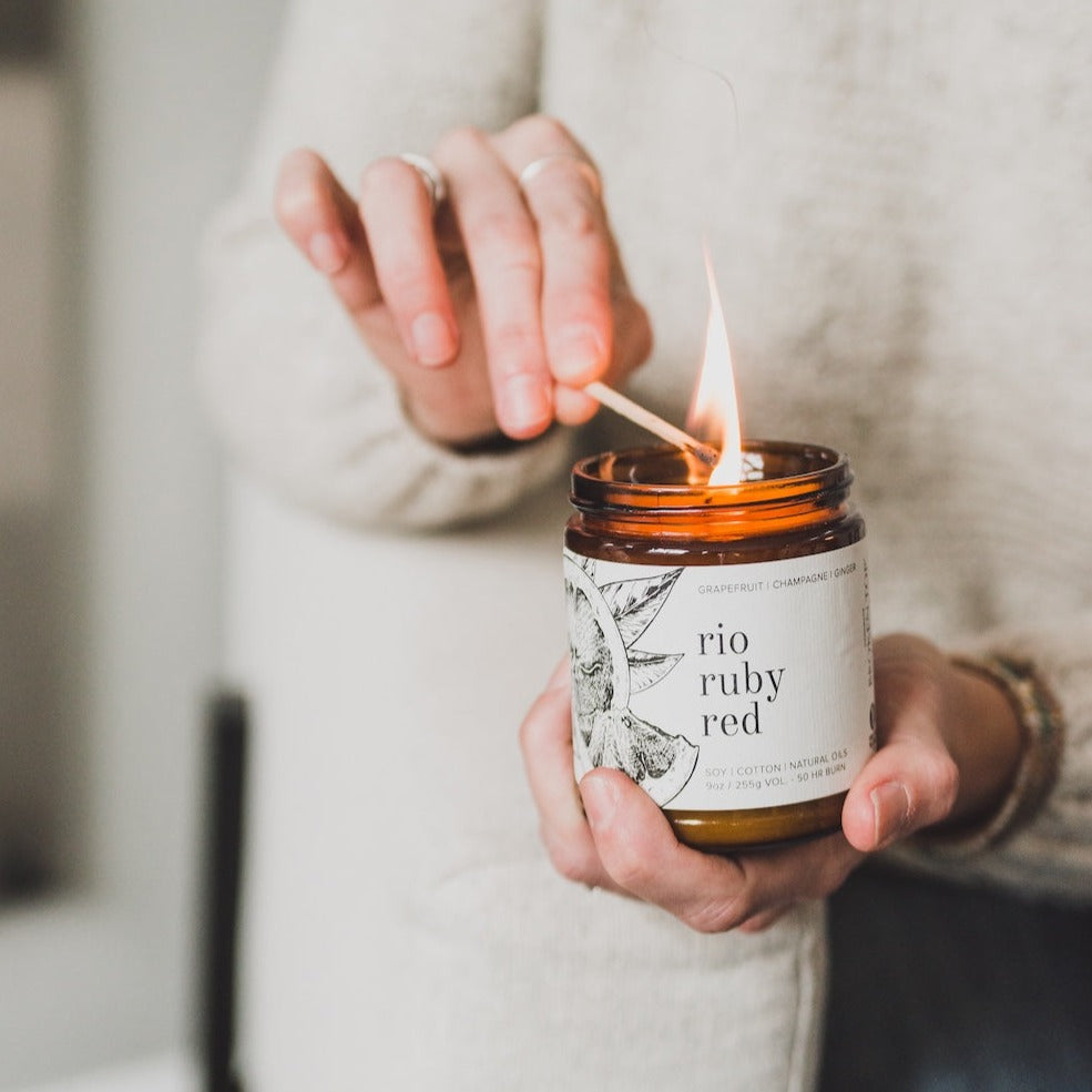 9oz Rio Ruby Red Soy Candle being lit with a match. 