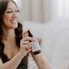 4oz Apricot Bloom Linen Spray being sprayed by a woman. 
