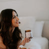 9oz Dusty Jasmine Soy Candle being held by a woman. 
