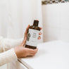 16oz Sea Salt Surf Body Wash being held by two hands. 