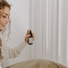 4oz Saguaro Cactus Linen Spray being sprayed by a woman. 