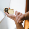 Tobacco Teak Solid Cologne being applied with two hands. 