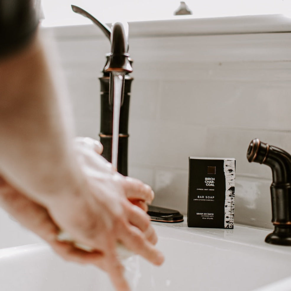 Birch Charcoal Bar Soap beside a sink. 