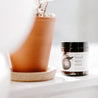 4oz Fresh Squeezed Soy Candle on window sill next to a ceramic pot. 