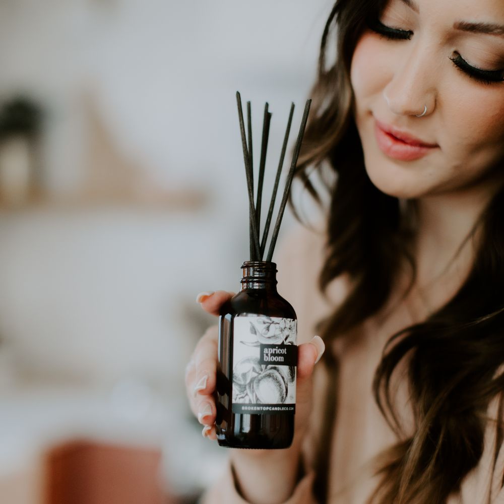 Apricot Bloom Reed Diffuser being held by a woman. 