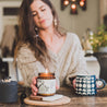 9oz Oakmoss Fig Soy Candle being held by a woman's hand. 