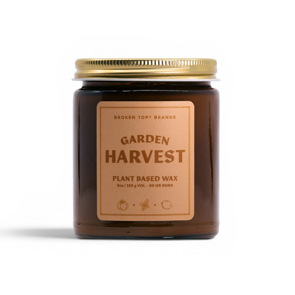 Candle jar labeled 'Garden Harvest' with a gold lid on a white background