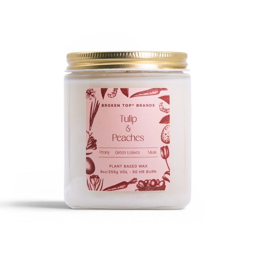 Candle jar with a pink label featuring illustrations and text on a white background