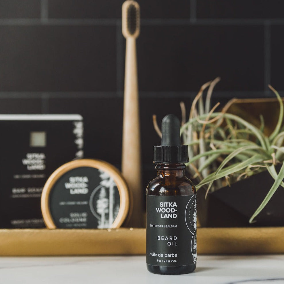 1oz Sitka Woodland Beard Oil on bathroom counter with grooming products in the background. 