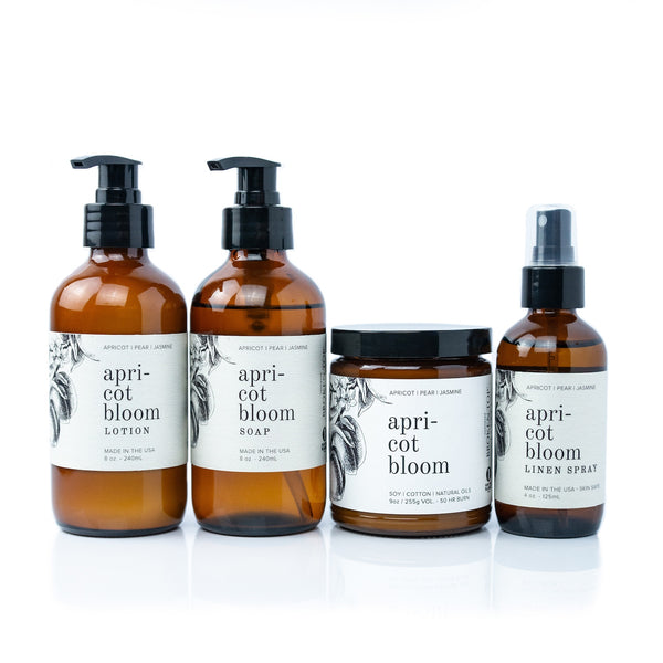Apricot Bloom Bundle including 8oz Apricot Bloom Body Lotion, 8oz Apricot Bloom Liquid Soap, 9oz Apricot Bloom Soy Candle, and 4oz Apricot Bloom Linen Spray on white background.