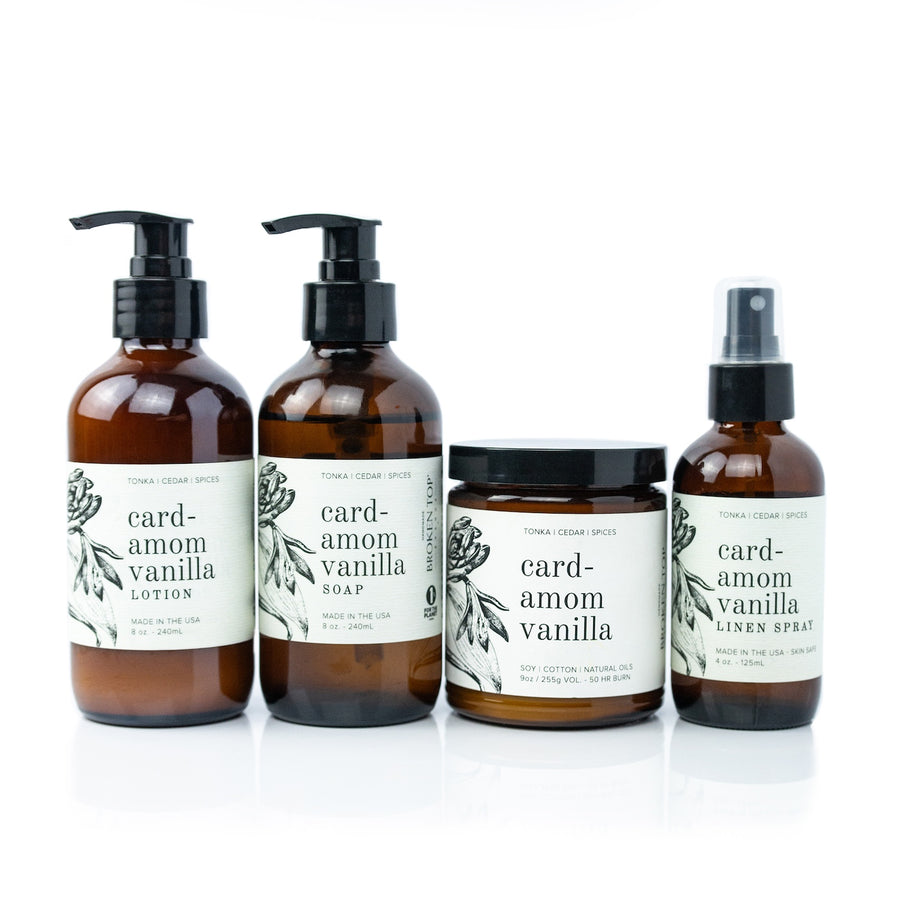 Cardamom Vanilla Bundle including 8oz Cardamom Vanilla Body Lotion, 8oz Cardamom Vanilla Liquid Soap, 9oz Cardamom Vanilla Soy Candle, and 4oz Cardamom Vanilla Linen Spray on white background. 