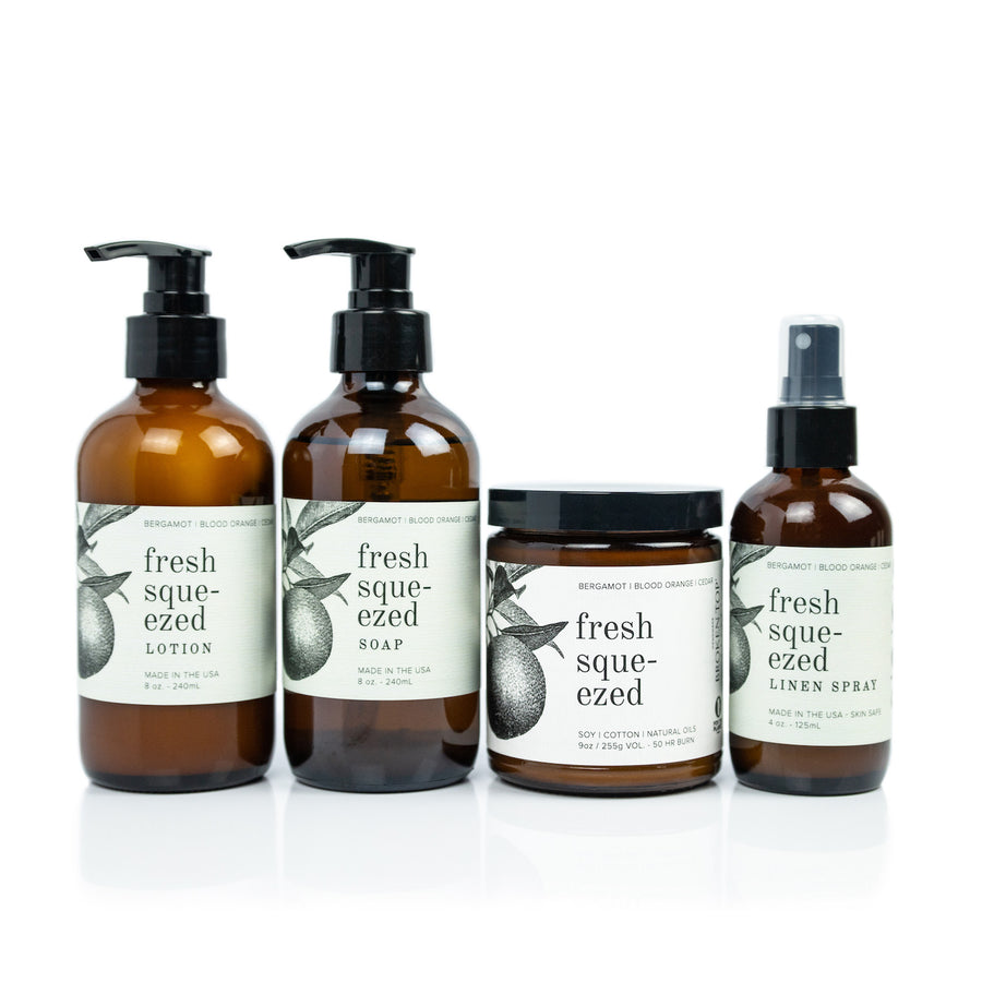 Fresh Squeezed Bundle including 8oz Fresh Squeezed Body Lotion, 8oz Fresh Squeezed Liquid Soap, 9oz Fresh Squeezed Soy Candle, and 4oz Fresh Squeezed Linen Spray on white background. 