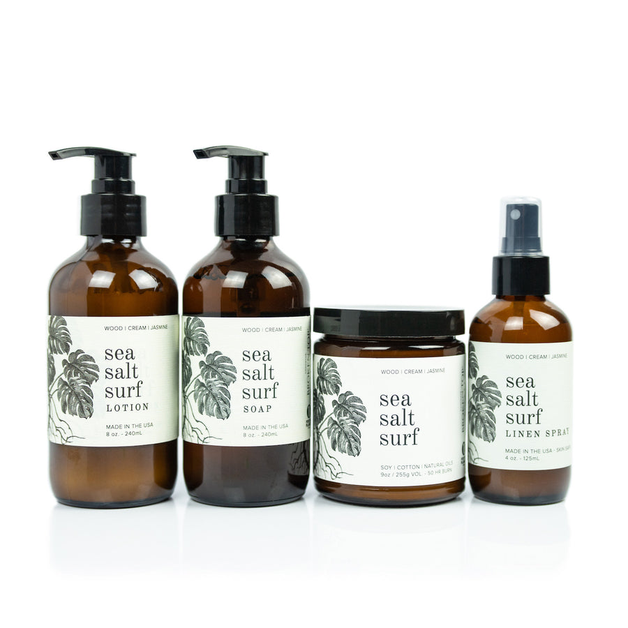 Sea Salt Surf Bundle including 8oz Sea Salt Surf Body Lotion, 8oz Sea Salt Surf Liquid Soap, 9oz Sea Salt Surf Soy Candle, and 4oz Sea Salt Surf Linen Spray on white background. 