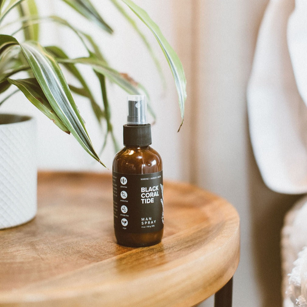 4oz Birch Charcoal Man Spray on wooden side table. 