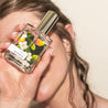 Woman holding Bosque Perfume in front of her face.