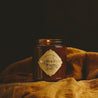 9oz Buttered Rum Soy Candle on draped yellow fabric. 