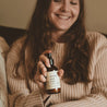 4oz Christmas Tree Linen Spray being sprayed by a woman with long brown hair. 