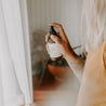 4oz Citrus Herbed Tonic Linen Spray being sprayed by woman's hand. 