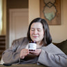 9oz Coconut Pecan Soy Candle being smelled by a woman. 