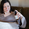 4oz Coconut Pecan Linen Spray being sprayed by a woman. 