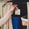 Coconut Sandalwood Car Freshener being placed above garbage cans. 