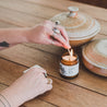 4oz Coconut Sandalwood Soy Candle being lit by a match. 
