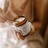 9oz Coconut Sandalwood Soy Candle being lit by a match. 