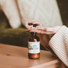 8oz Cranberry Orange Body Lotion being dispensed into a woman's hands. 