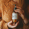 8oz Cranberry Orange Body Lotion being held by two woman's hands. 