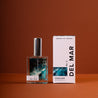 Del Mar Perfume and box on dark orange background. 