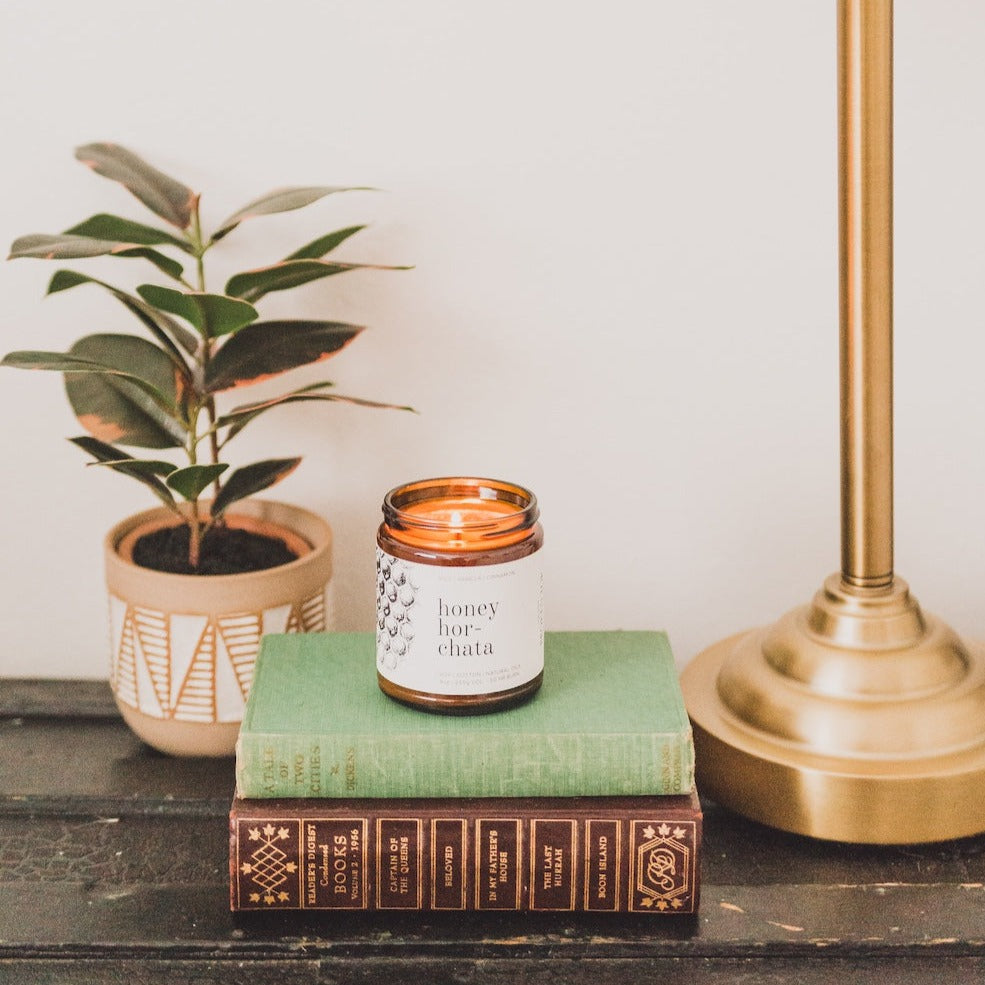 9oz Honey Horchata Soy Candle atop two books. 