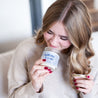 'Spill The Tea Sis' 9oz Soy Candle being smelled by a young woman. 