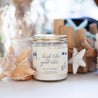 'High Tides & Good Vibes' 9oz Soy Candle next to sea shells. 