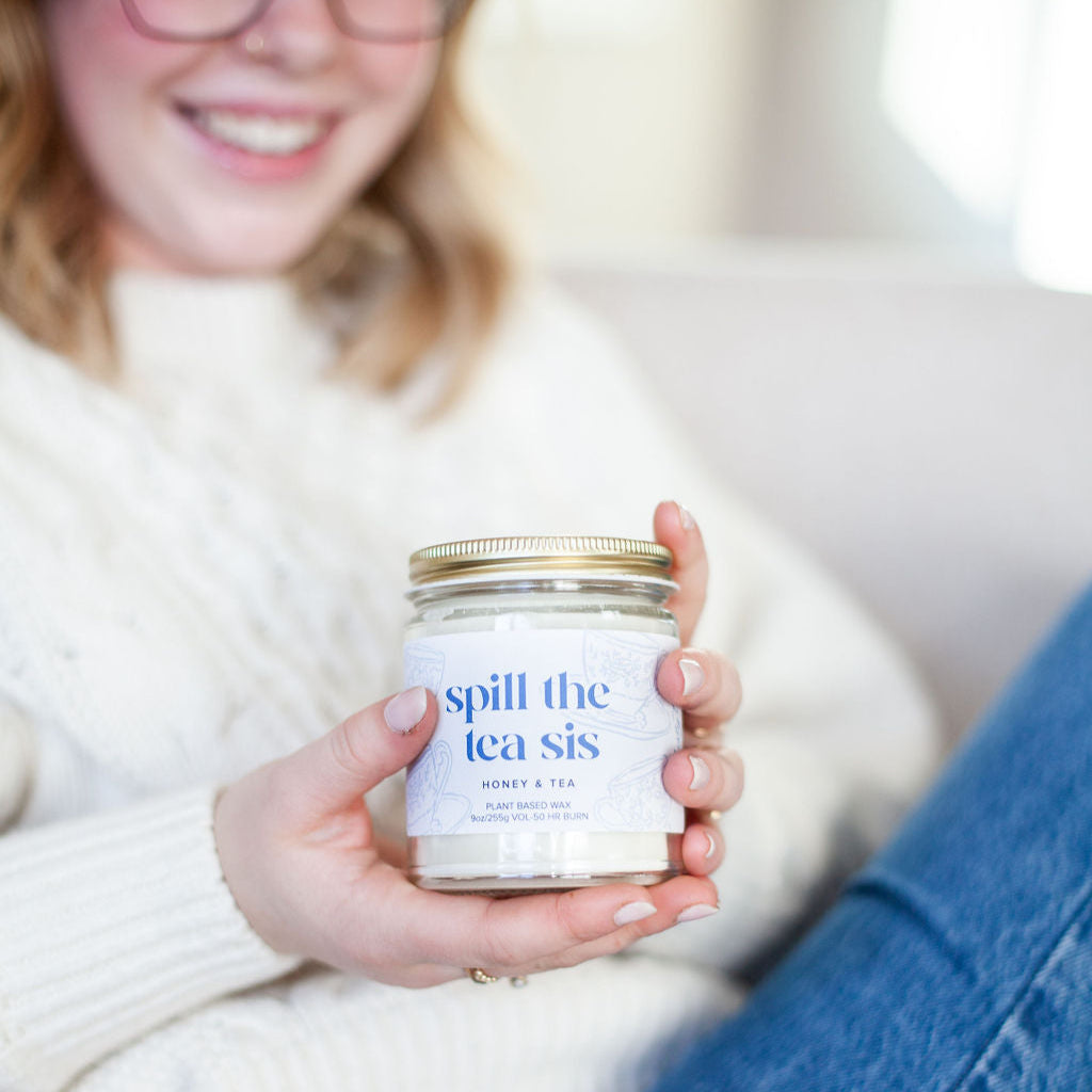 'Spill The Tea Sis' 9oz Soy Candle being held by a woman's hands. 