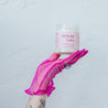 'Birthday Babe' 9oz Soy Candle being held by a hand in a pink glove. 