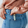 Austy Lou Vanilla Sky Roll-On Perfume being placed in back pocket of denim jeans. 