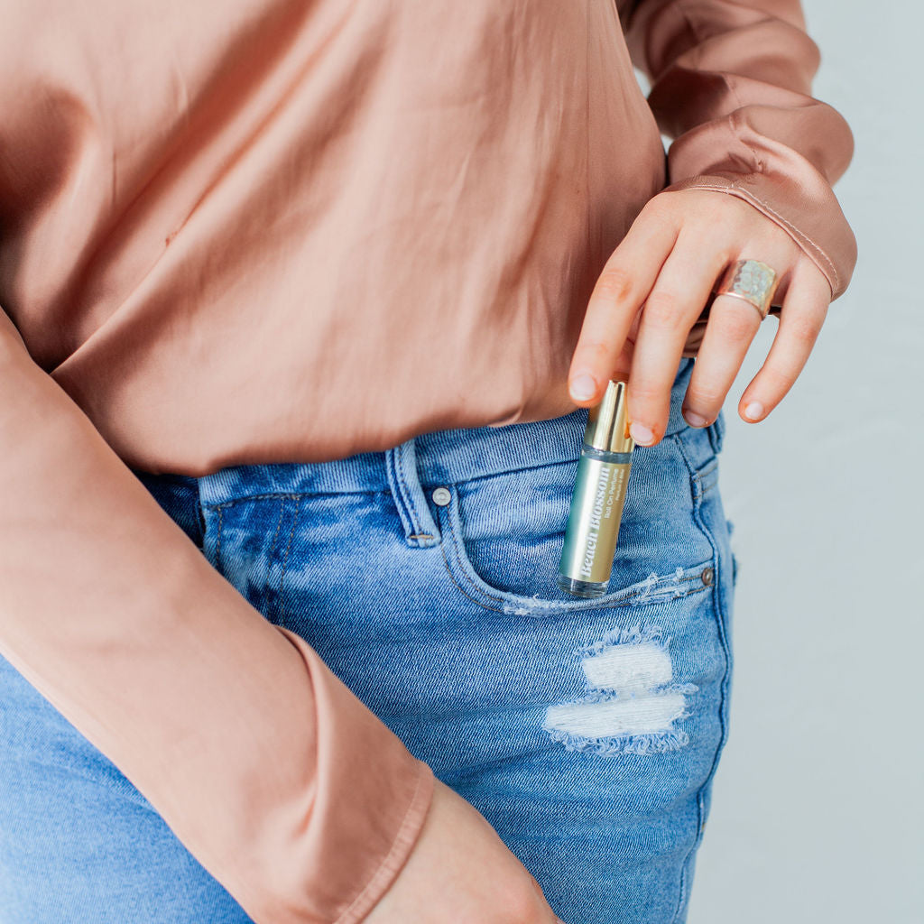 Austy Lou Beach Blossom Roll-On Perfume being removed from a denim pocket. 