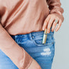 Austy Lou Beach Blossom Roll-On Perfume being removed from a denim pocket. 