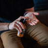 8oz Tobacco Teak Body Lotion being dispensed into men's hands. 