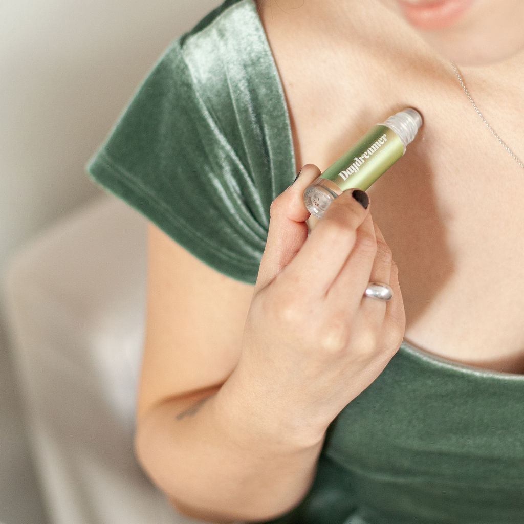 Austy Lou Daydreamer Roll-On Perfume being applied to a woman's neck. 