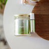 Austy Lou Daydreamer Roll-On Perfume on a white side table next to an Austy Lou Daydreamer 9oz Soy Candle. 