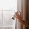 4oz Lavender Mint Linen Spray being sprayed by a hand. 