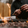 Lemon Citronella Outdoor Incense Cone Kit next to fire pit with a man lighting a match. 
